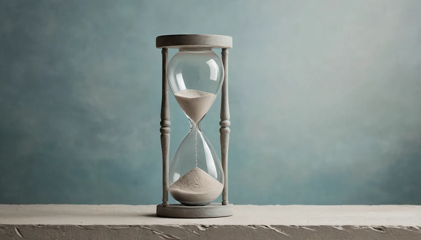 An hourglass with pale sand running on a stone ledge